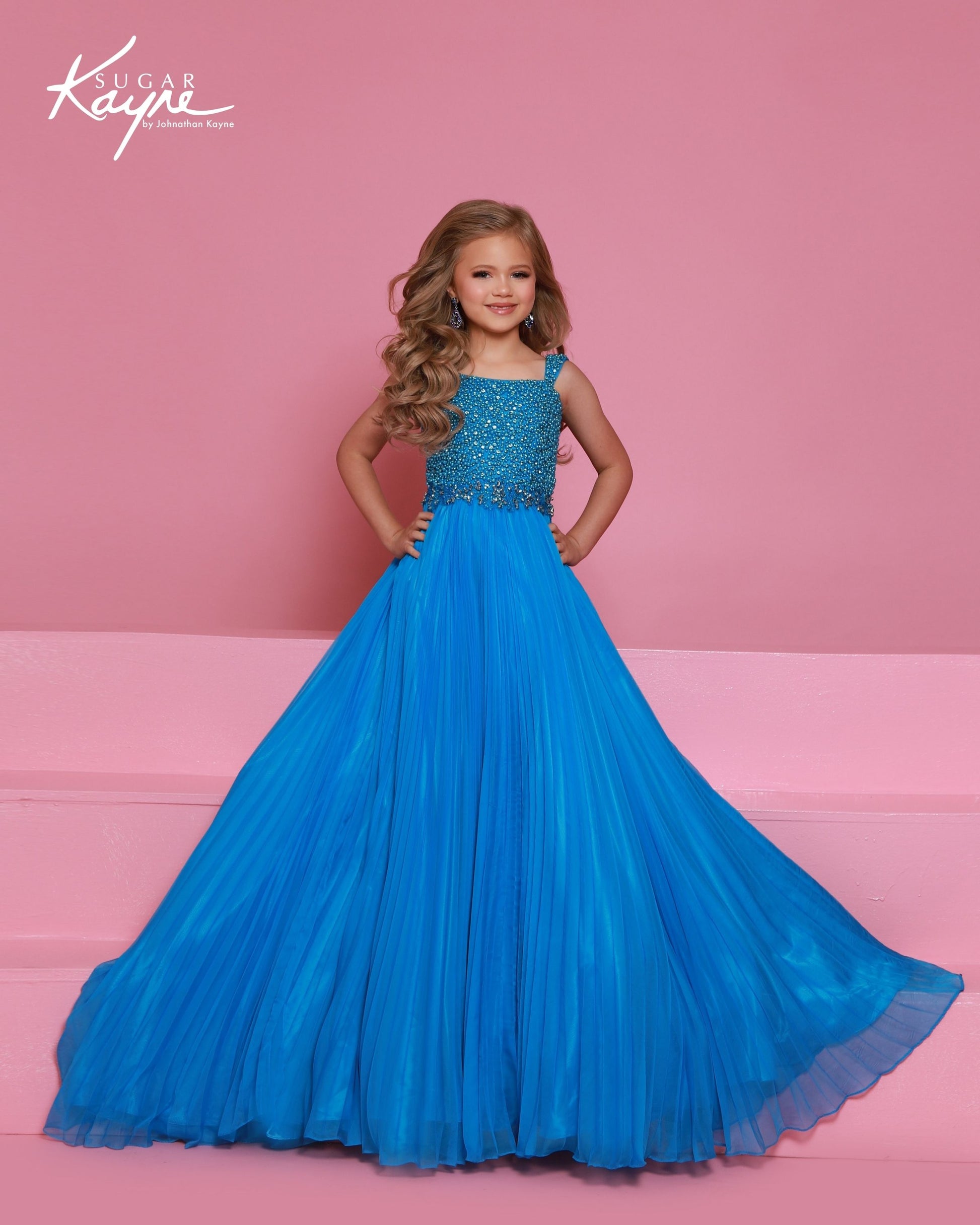 Designer: Sugar Kayne — Style C408
This lightweight Sugar Kayne girls pageant dress, style C408, showcases flowing chiffon over a satin lining for effortless drape and motion. The look is soft, feminine, and comfortable, giving her a confident presence from interview to evening wear on the pageant stage.

Sizes: 2–16
Colors: Hot Pink, Turquoise, White