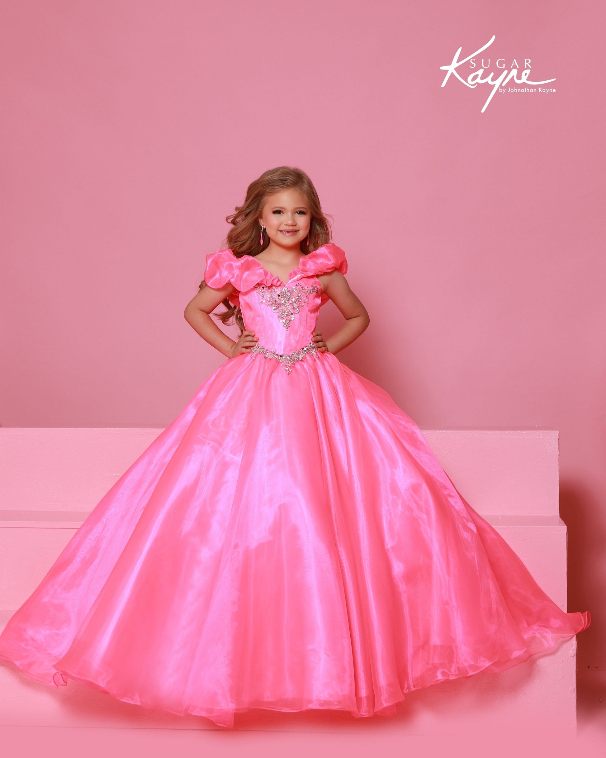 Designer: Sugar Kayne — Style C410
Sugar Kayne style C410 is a classic girls pageant dress with layered organza and a smooth satin lining for beautiful volume and shine. The full skirt and refined bodice give this gown timeless pageant appeal, making it ideal for everything from local titles to national stages.

Sizes: 2–16
Colors: Canary, Neon Pink, Turquoise