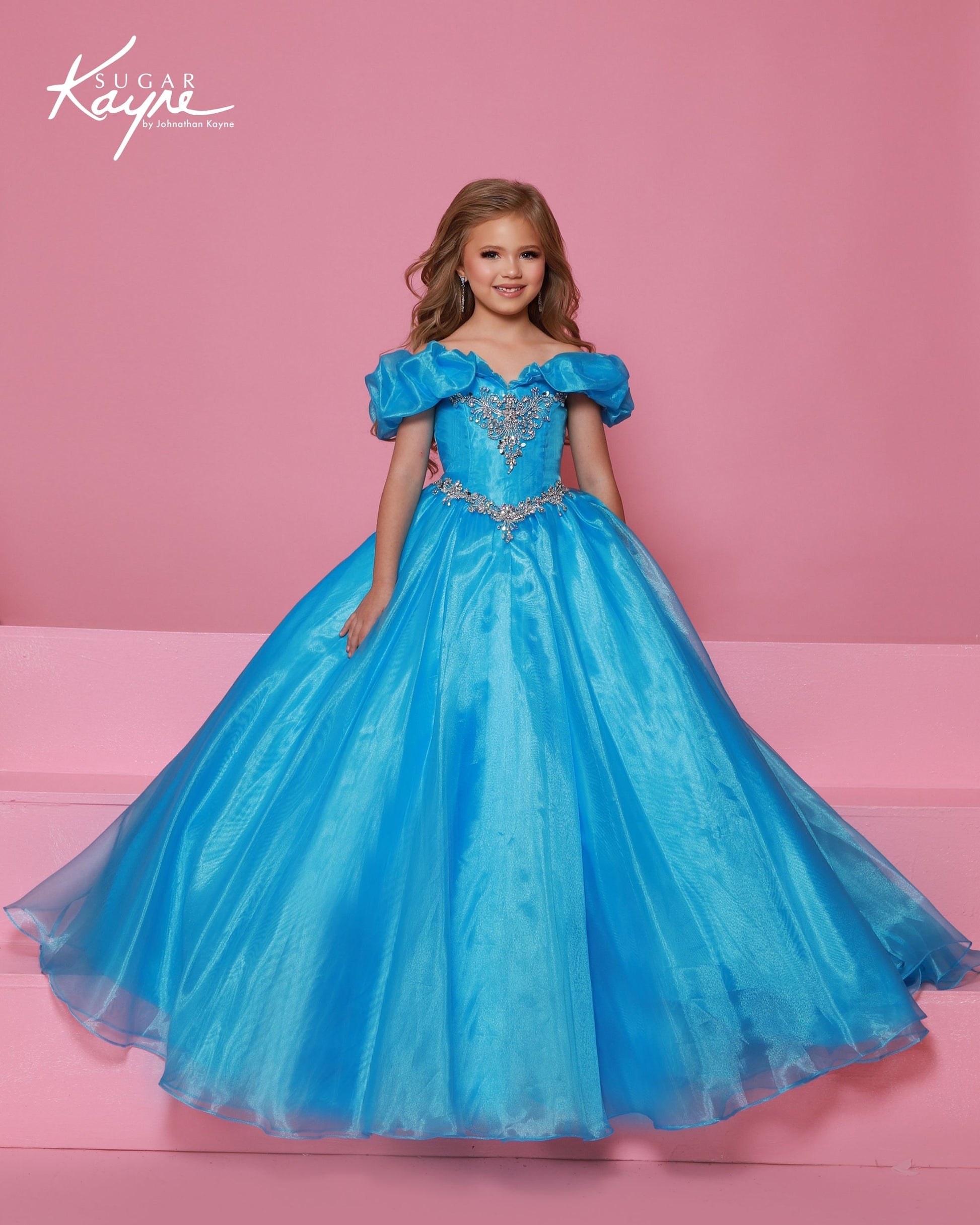 Designer: Sugar Kayne — Style C410
Sugar Kayne style C410 is a classic girls pageant dress with layered organza and a smooth satin lining for beautiful volume and shine. The full skirt and refined bodice give this gown timeless pageant appeal, making it ideal for everything from local titles to national stages.

Sizes: 2–16
Colors: Canary, Neon Pink, Turquoise