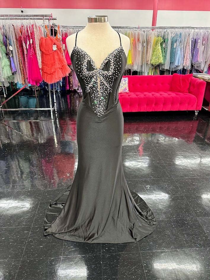Indulge in the ultimate luxury with the Jovani D5054 Fitted backless satin prom dress. Featuring a crystal bow bodice and formal evening gown design, this dress exudes sophistication and elegance. The fitted silhouette accentuates your curves while the backless design adds a touch of sensuality. Make a statement at your next event with this exclusive piece. Experience elegance in this captivating gown featuring a floor-length silhouette that gracefully glides with every step. The dress boasts an illusion sw