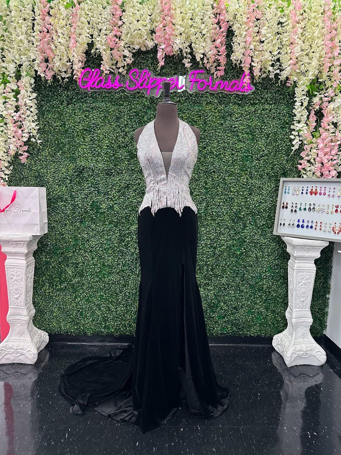 Elevate your formal wardrobe with the Johnathan Kayne 2534 gown, expertly crafted in rich black velvet. This size 4 dress features a crystal-embellished bodice that adds refined sparkle, while the halter corset design offers structured support and a flattering silhouette. The long fitted skirt includes a tasteful slit, combining elegance with a touch of allure—ideal for pageants or upscale events. This gown balances sophistication and glamour, ensuring you make a confident statement at any special occasion.