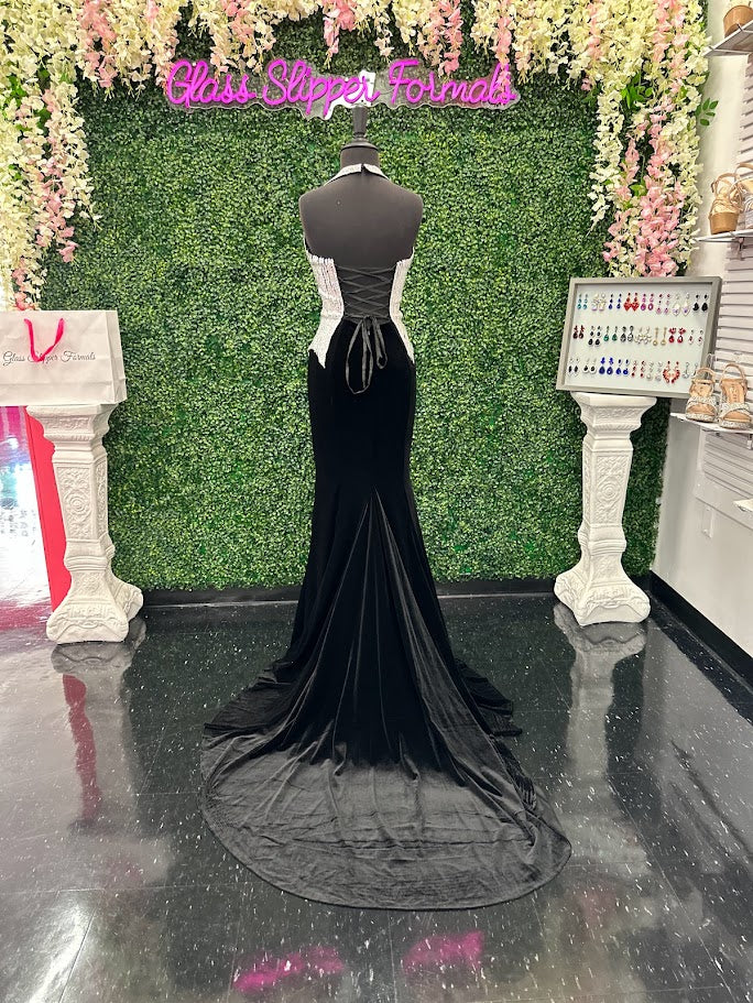 Elevate your formal wardrobe with the Johnathan Kayne 2534 gown, expertly crafted in rich black velvet. This size 4 dress features a crystal-embellished bodice that adds refined sparkle, while the halter corset design offers structured support and a flattering silhouette. The long fitted skirt includes a tasteful slit, combining elegance with a touch of allure—ideal for pageants or upscale events. This gown balances sophistication and glamour, ensuring you make a confident statement at any special occasion.