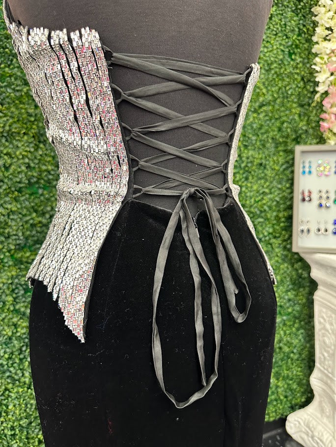 Elevate your formal wardrobe with the Johnathan Kayne 2534 gown, expertly crafted in rich black velvet. This size 4 dress features a crystal-embellished bodice that adds refined sparkle, while the halter corset design offers structured support and a flattering silhouette. The long fitted skirt includes a tasteful slit, combining elegance with a touch of allure—ideal for pageants or upscale events. This gown balances sophistication and glamour, ensuring you make a confident statement at any special occasion.