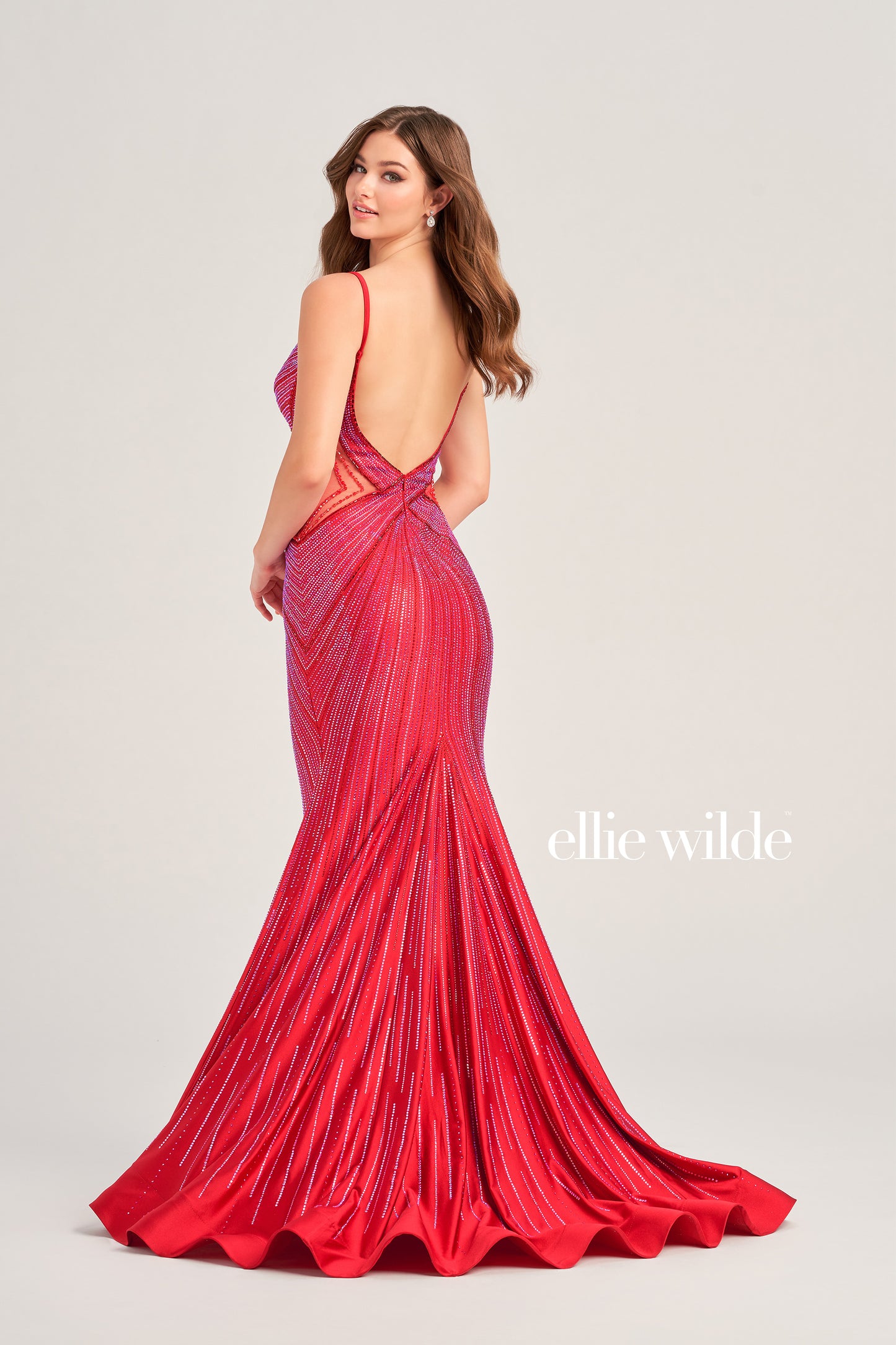This Ellie Wilde formal dress is perfect for any prom or special event. The fitted crystal jersey construction features sheer mesh cutouts on the sides and a backless mermaid design for a perfect fit. It's finished with a low v-neck for a timeless look.  COLOR: BLACK, LIGHT BLUE, NAVY BLUE, ROYAL BLUE, HOT PINK, RUBY, IRIS, LAVENDER FROST SIZE: 00 - 20