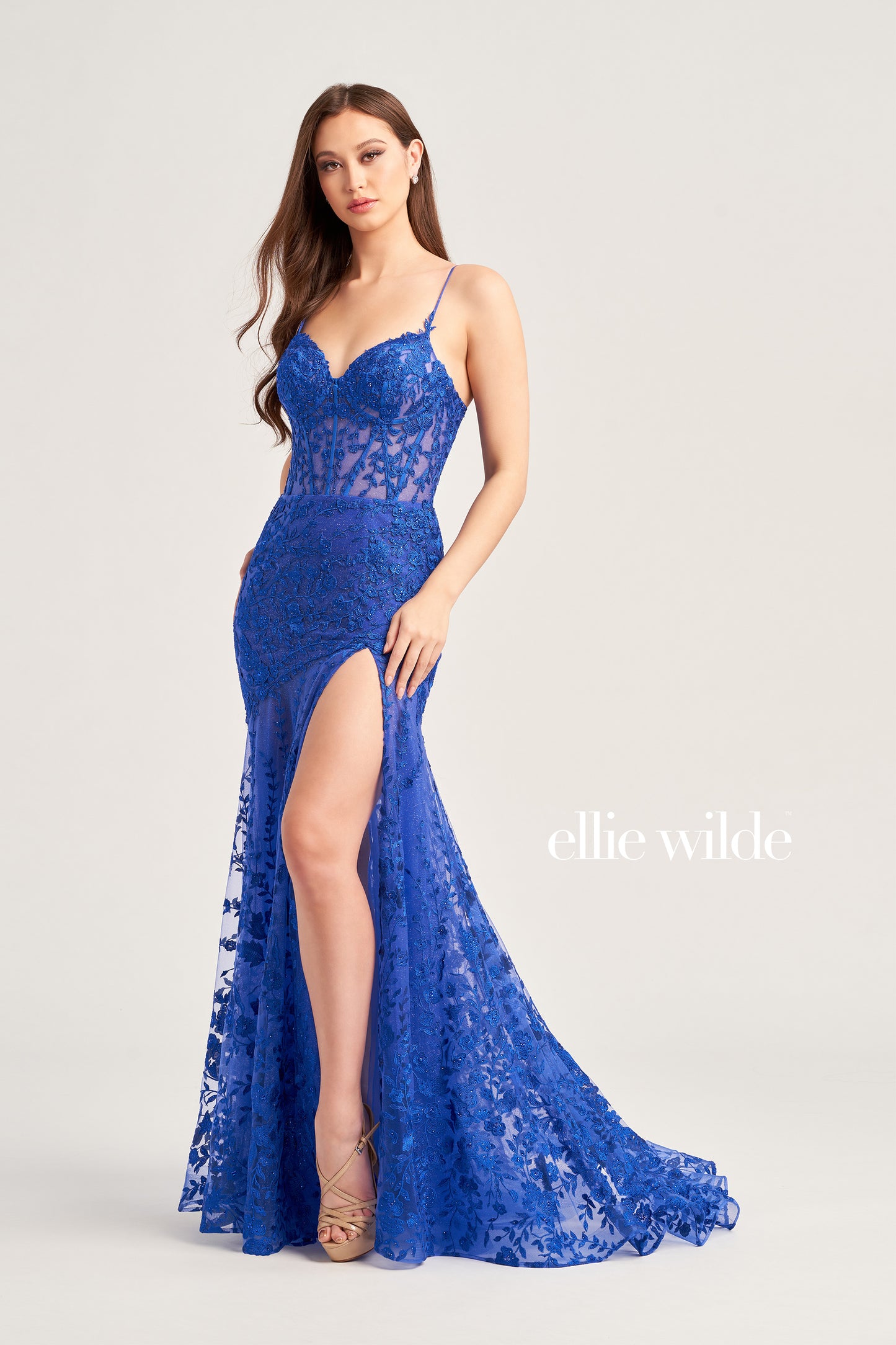 This Ellie Wilde EW35005 Sheer Corset Shimmer Lace Slit Prom Dress Formal Gown adds an elegant touch to formal events. Featuring a sheer corset with shimmer lace and an asymmetrical sheer skirt train, this gorgeous gown will make you stand out. Perfect for the special night.  COLOR: RED, LIGHT YELLOW, LIGHT BLUE, MAGENTA, ROYAL BLUE, EMERALD/NUDE, SAGE SIZE: 00 - 16