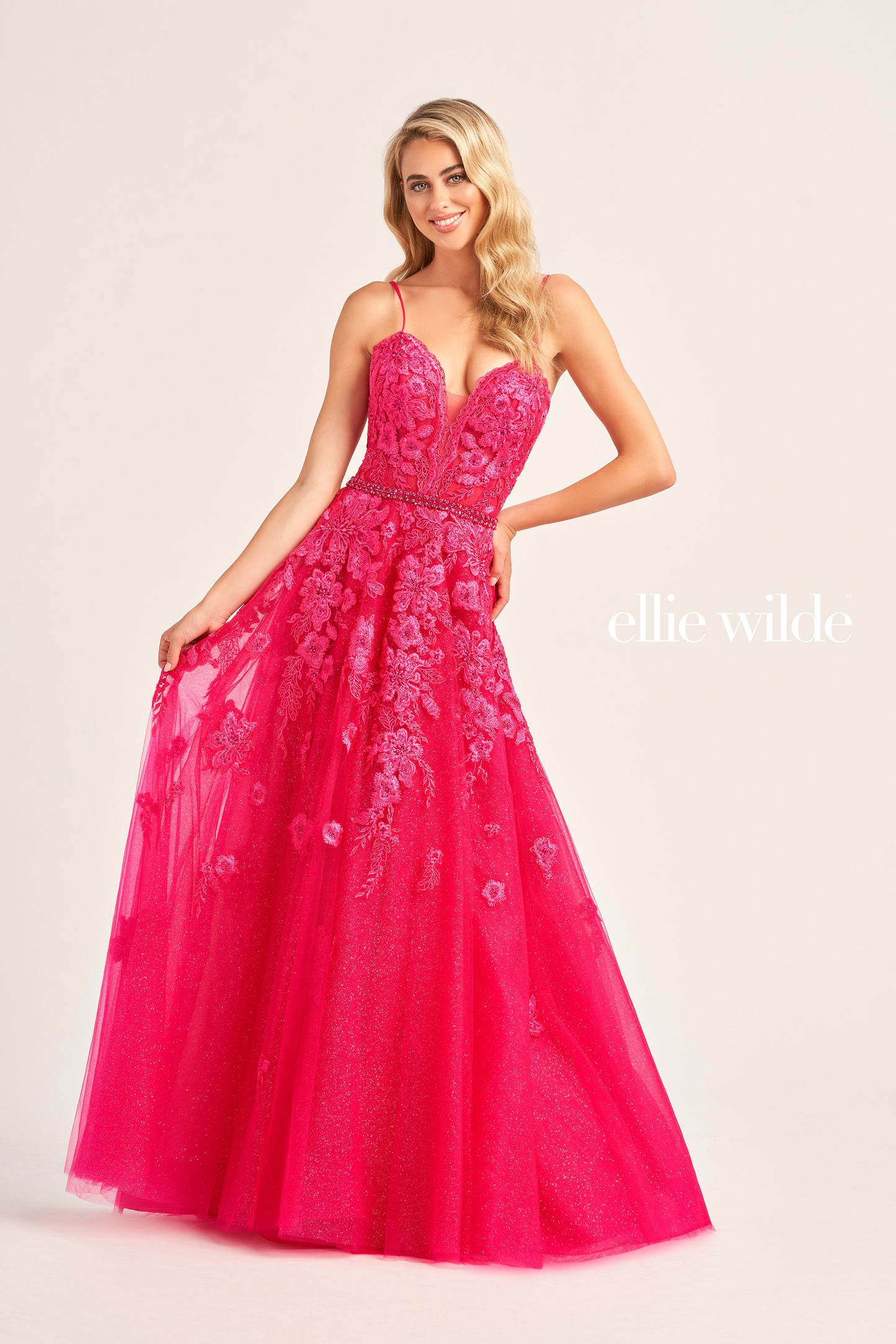 Look stunning in Ellie Wilde’s EW35016 long A Line dress. Crafted with shimmering Glitter Tulle, Lace Appliques, Organza and Stone Accents, this dress radiates elegance and artisan craftsmanship. Its one-shoulder style and Sweetheart neckline fit the body perfectly, while its pockets provide added convenience. Its natural waistline and long length adds that perfect finishing touch.  COLOR: ORANGE, PINK, YELLOW, MAGENTA, EMERALD, SEA GLASS, STRAWBERRY, BLUEBELL SIZE: 00 - 24
