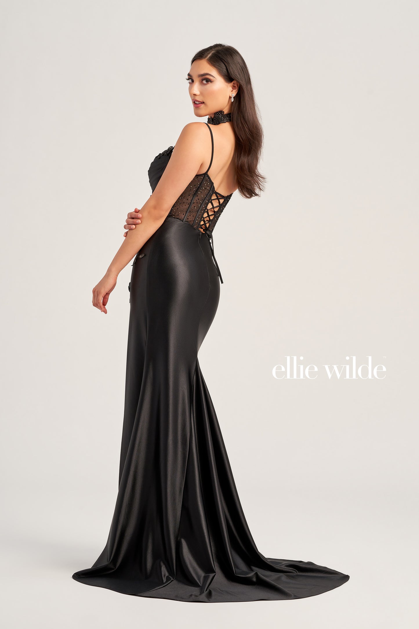 Look and feel your best in the Ellie Wilde EW35028 Long Sheer Corset Lace Formal Dress. This ultra-flattering evening gown features an alluring sweetheart neckline with lace choker detail, corset bodice, and a fit and flare silhouette, enhanced by lace appliques and stone accents. The luxe stretch satin jersey drapes effortlessly and the high slit adds movement and depth. Dazzle them with your entrancing look and effortless style.  COLOR: BLACK, RED, EMERALD, DARK PURPLE SIZE: 00 - 20