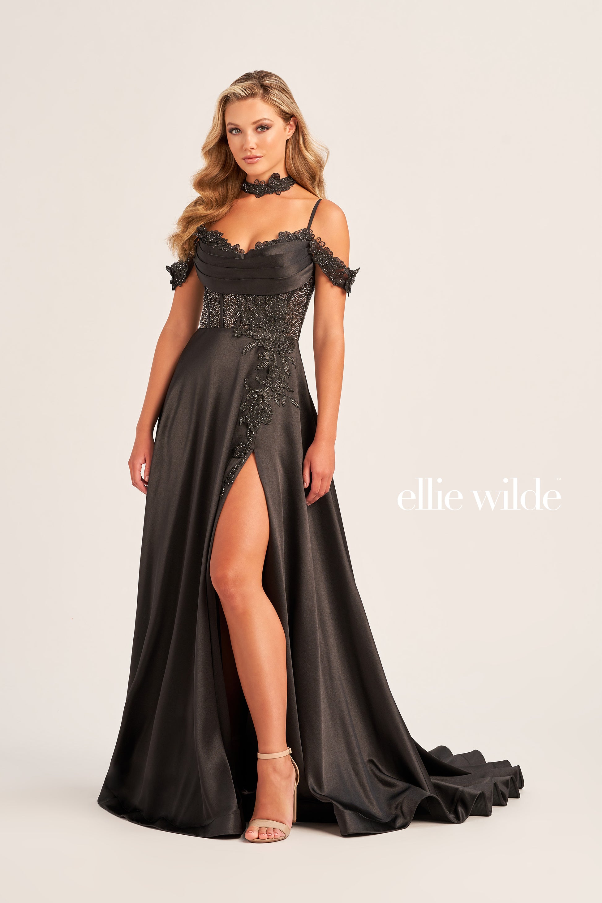 Look like a modern-day royalty in the Ellie Wilde EW35029 Long Satin A Line Maxi Slit Prom Dress Lace Crystal Corset off the shoulder gown featuring intricate Lace Appliques, Satin, and Stone Accents in a Sweetheart neckline and natural waistline silhouette. A must-have for your prom wardrobe, this modern design features an eye-catching Corset Bodice,