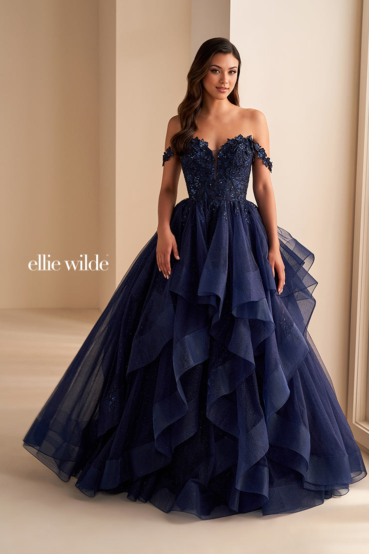 Make a statement in the Ellie Wilde EW35084 prom dress. Featuring an off-the-shoulder top, shimmer sequin lace and ruffle detail, the dress offers a timeless and sophisticated look perfect for the big night. Keep it classic in this classic formal gown.

Sizes: 00-24

Colors: Bluebell, Diamond White, Dusty Rose/Gold, Emerald, Hot Pink, Lavender, Light Pink, Light Yellow, Navy, Red, Royal, Silver, Teal, Wine&nbsp;