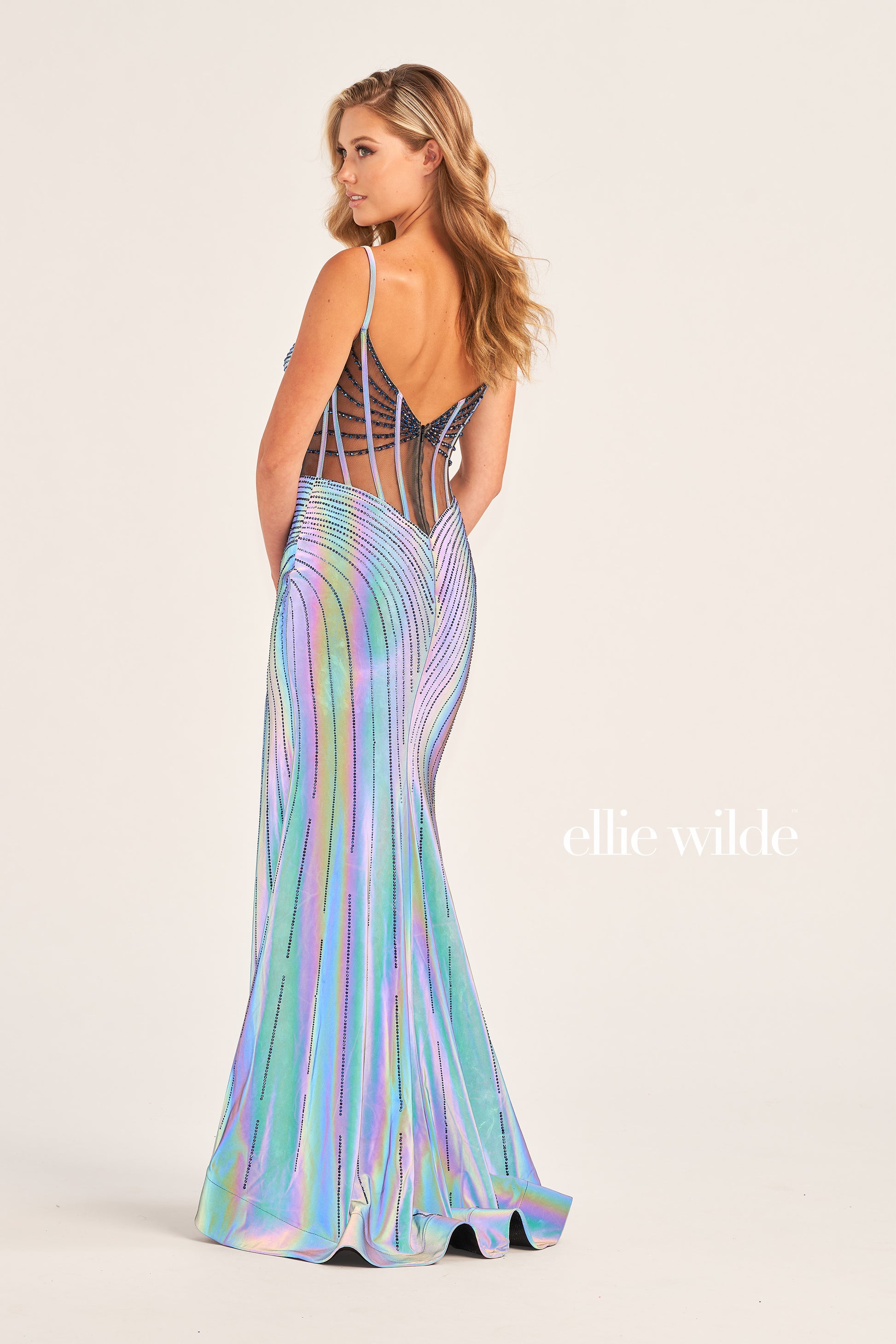 The Ellie Wilde EW35702 SUPERNOVA Holographic Sheer Corset Prom Dress Slit V Neck Gown is perfect for special occasions. Crafted with a romantic sheer illusion bodice, intricate metallic beading, and a striking slit skirt, this gown is the perfect combination of glamour and femininity. The corset bodice ensures a flattering fit, while the unexpected cut of the neckline adds drama and sophistication. Nothing gets more wows than this!