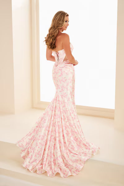 Ellie Wilde's EW37092 is a sophisticated prom dress that combines timeless elegance with contemporary design. Crafted from luxurious satin, this strapless gown features a striking floral print that adds visual interest and dimension. The fitted bodice showcases a dramatic cut-out corset detail that creates an alluring focal point, while the fit-and-flare silhouette with a thigh-high slit offers both flattering structure and graceful movement. Perfect for prom, formal events, or special occasions where you w