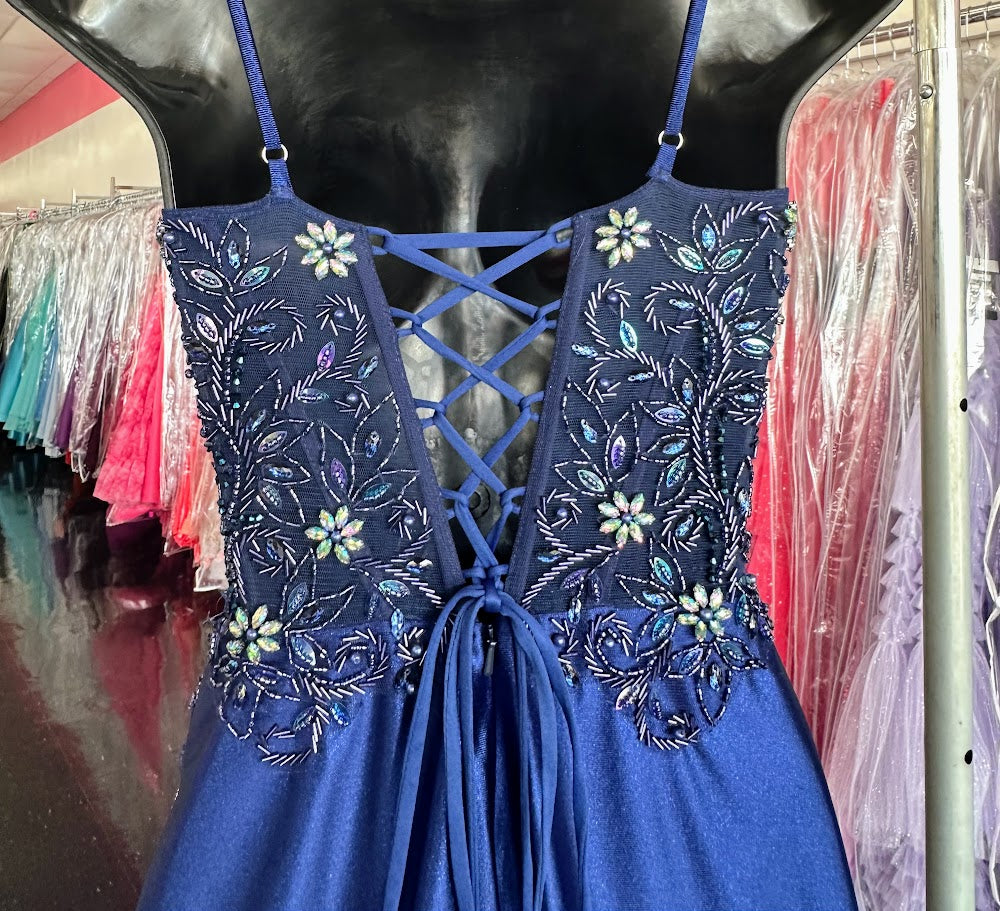 This Nox Anabel G1659 gown in size 0 features a sophisticated navy satin fabric with a long, fitted silhouette that enhances your figure. The dress is adorned with delicate beadwork and crystals, adding refined sparkle. A sheer corset bodice offers subtle allure, while the slit skirt provides elegant movement and ease. Perfect for formal occasions, this gown combines classic craftsmanship with modern detailing for a standout look.

Size: 0

Color: Navy Blue