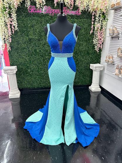 The Johnathan Kayne 2628 is a glamorous pageant dress, crafted from fitted scuba for a sleek and form-flattering effect. The gown features a crystal accented waist line, shoulder straps and v neckline with scattered crystals and glittering accents, making it perfect for special occasions. With its comfortable fit and elegant design, this size 4 dress adds sparkle to any ensemble. Color Block Combo.  *Theses are ONE OF A KIND!  Size: 4  Color: Royal/Aqua