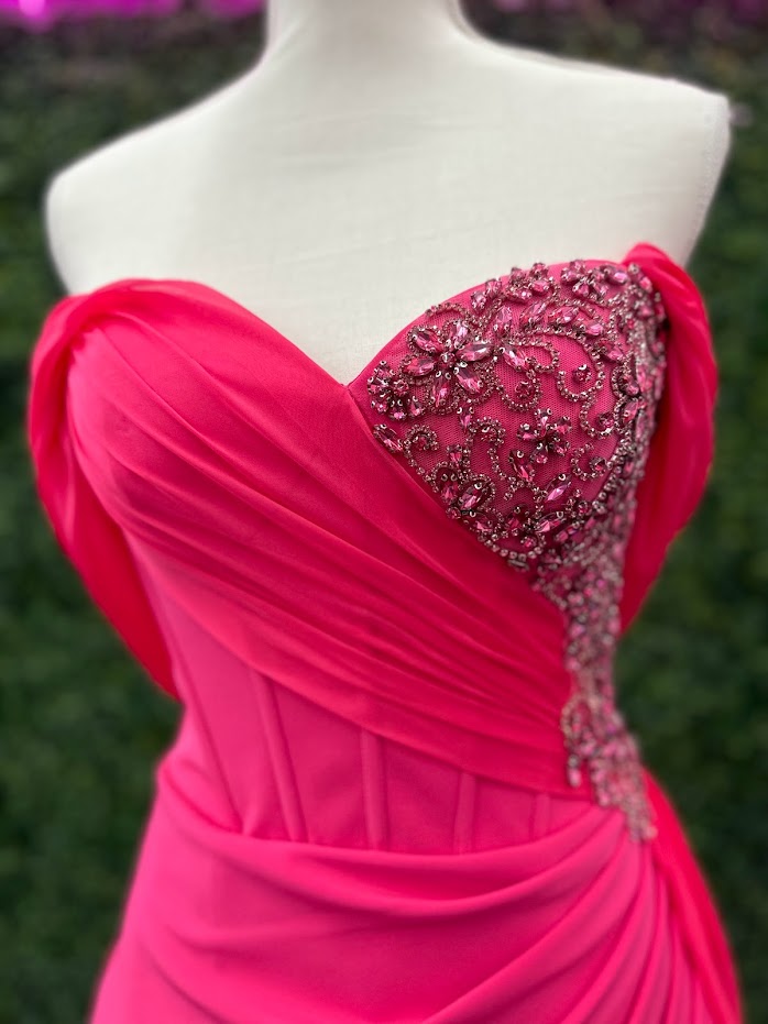 The Lucci Lu 1348 Pageant Dress is a stunning style for any special occasion. It features a fuchsia corset wrap, off the shoulder design that softly drapes around the back of the arms.  slit skirt with a chiffon overskirt. This size 4 dress will surely make you stand out. boning in corset style bodice with detailed beading and crystals  Size: 4  Color: Fuchsia