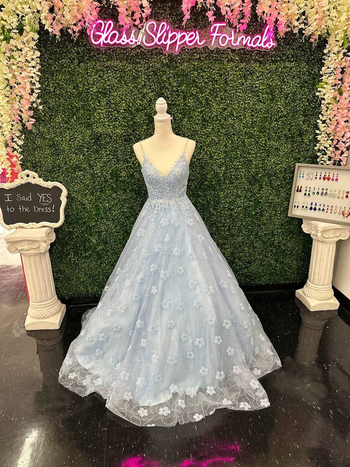 This Blue Sequin Lace Shimmer Ballgown by Johnathan Kayne features high quality sequin detailing on the bodice and skirt to create a dramatic and eye-catching look. The sleeveless bodice has a modest neckline, while the floor-length skirt adds elegance and movement for the perfect prom dress. 3d Floral Tulle Appliques and sequins cascading down the skirt.  *** One of A KIND!  Size: 4  Color: Light Blue