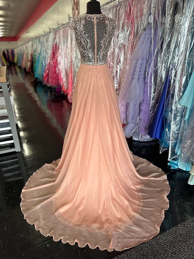 Elevate your formal occasion with the Johnathan Kayne 2750, a size 4 charcoal A-line gown designed for timeless elegance. Featuring a beaded high neckline and delicate cap sleeves, this dress combines refined detailing with a flowing chiffon train for graceful movement. Perfect for the mother of the bride or any distinguished event, it offers a sophisticated silhouette that enhances your presence with understated glamour.

Size: 4

Color: Blush