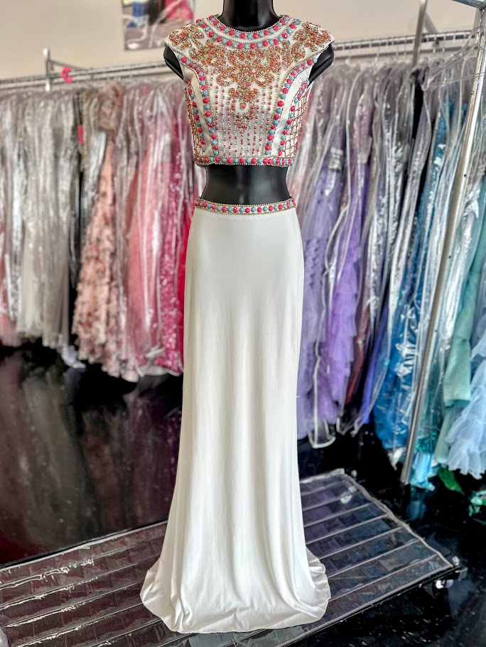 JVN by Jovani style JVN34015 Sexy two piece prom dress features sleeveless multicolored coral and mint beaded top with cutout back and a fitted jersey skirt.&nbsp;Two Piece Beaded Prom Dress High Neck Formal Gown JVN 34015

Available Size: 0

Available Color: White