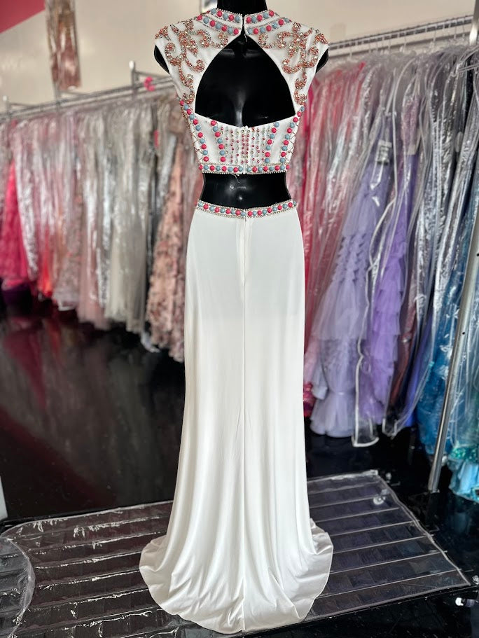 JVN by Jovani style JVN34015 Sexy two piece prom dress features sleeveless multicolored coral and mint beaded top with cutout back and a fitted jersey skirt.&nbsp;Two Piece Beaded Prom Dress High Neck Formal Gown JVN 34015

Available Size: 0

Available Color: White