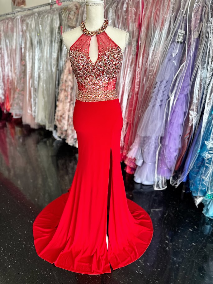 Make a striking entrance with the Jovani JVN23576, a size 2 red prom dress designed for confidence and elegance. This gown features a sheer long overlay paired with a chic choker neckline that frames the plunging neckline beautifully. A daring slit adds both allure and ease of movement, perfect for pageants or formal events. Crafted to enhance your silhouette, this dress balances bold design with refined sophistication.

Stunning halter form fitting dress features a sexy thigh high slit and crystal embellis