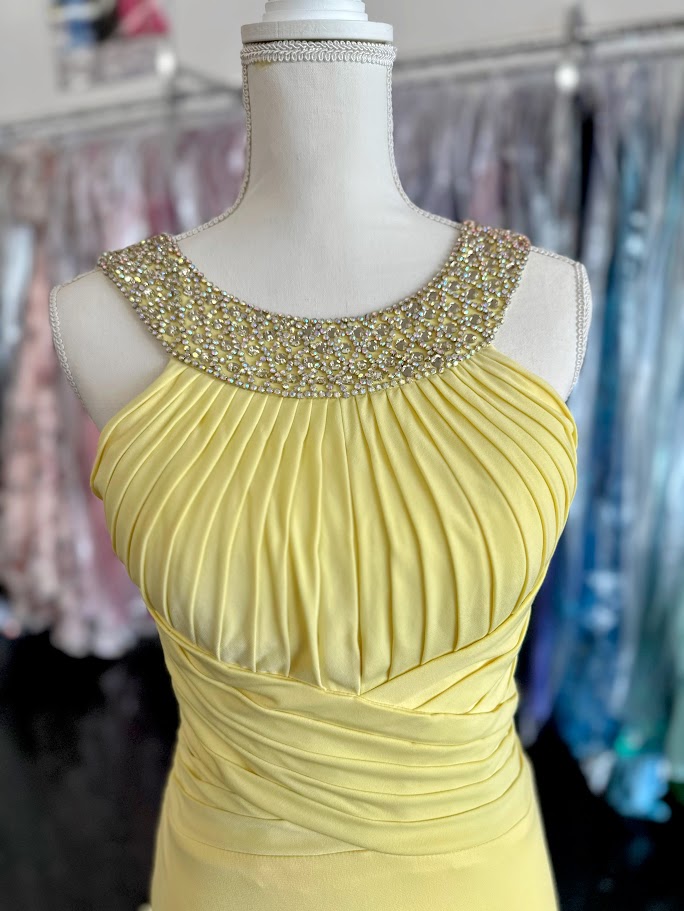 Jovani JVN93211 is a stunning Long Fitted Jersey Formal evening gown. Featuring a high Crystal Embellished Neckline and pleated bust with an asymmetrical bandage wrapped waist. This stunning Prom &amp; Pageant gown features a Slit in the skirt and sweeping train.

Available Size: 2

Available Color: Yellow