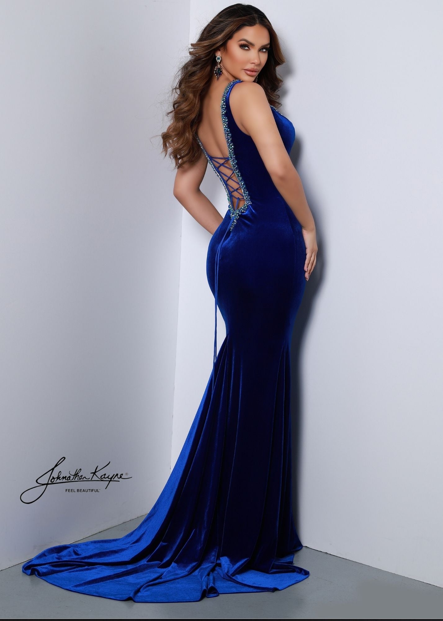 Look stunning in the Johnathan Kayne 2534 gown. Crafted from sleek stretch velvet, this gown features a V neckline and low back adorned in sparkling rhinestones. The corset back ensures a perfect fit. Perfect for special occasions, this piece is sure to make you shine.