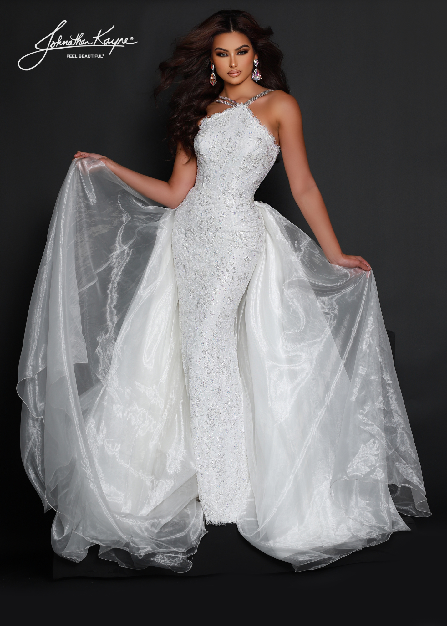 Look elegant with this Johnathan Kayne 2618 pageant dress. The high neck and sweeping long skirt are adorned with sequin lace and crystal detailing, perfect for any special occasion. Make a lasting impression.  This style is sure to be a knockout at your next pageant! Walk across stage with confidence in this halter neck beaded stretch lace fitted gown with organza overskirt.  Colors: Barbie Pink, Royal, Red, White  Sizes: 00-22