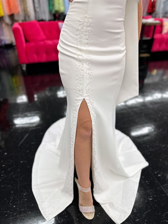 This elegant Johnathan Kayne dress in size 4 features a long ivory crepe silhouette that combines sophistication with subtle drama. Detailed with delicate beaded sequins, it offers a refined shimmer, while the slit adds a modern edge. Draped sleeves and a tasteful bow accentuate the design, creating a balanced look of grace and contemporary style—ideal for formal occasions where expert craftsmanship and timeless elegance are paramount. One Shoulder. *One of A Kind!

Size: 4

Color: Ivory