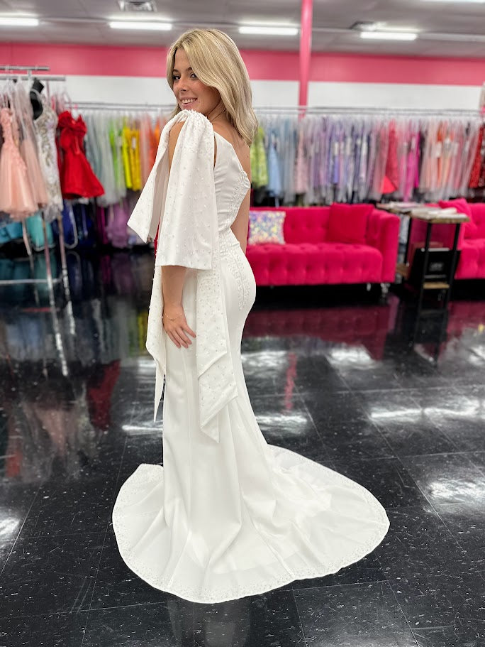 This elegant Johnathan Kayne dress in size 4 features a long ivory crepe silhouette that combines sophistication with subtle drama. Detailed with delicate beaded sequins, it offers a refined shimmer, while the slit adds a modern edge. Draped sleeves and a tasteful bow accentuate the design, creating a balanced look of grace and contemporary style—ideal for formal occasions where expert craftsmanship and timeless elegance are paramount. One Shoulder. *One of A Kind!

Size: 4

Color: Ivory