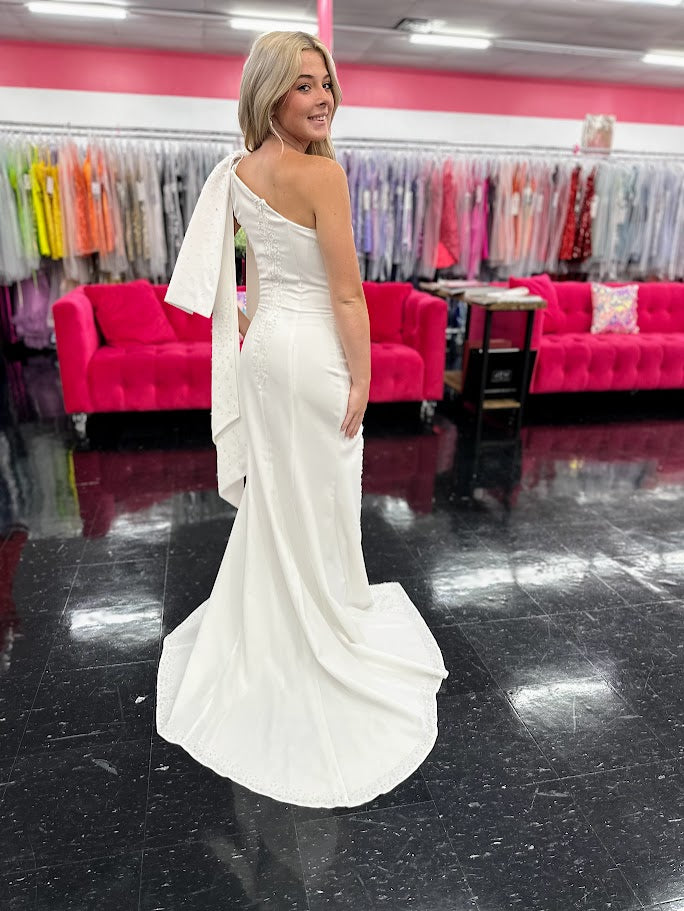 This elegant Johnathan Kayne dress in size 4 features a long ivory crepe silhouette that combines sophistication with subtle drama. Detailed with delicate beaded sequins, it offers a refined shimmer, while the slit adds a modern edge. Draped sleeves and a tasteful bow accentuate the design, creating a balanced look of grace and contemporary style—ideal for formal occasions where expert craftsmanship and timeless elegance are paramount. One Shoulder. *One of A Kind!

Size: 4

Color: Ivory