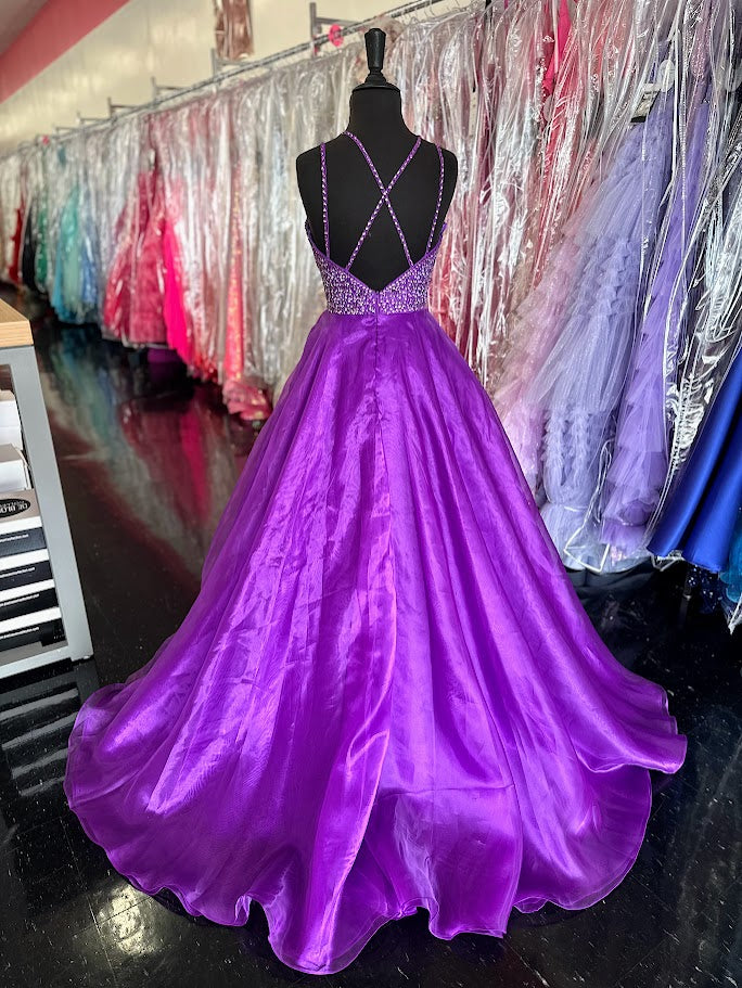 Elevate your prom night with the Johnathan Kayne 7219 long ballgown in a stunning coral hue. This size 4 dress features a graceful A-line silhouette complemented by a crystal-embellished V-neck, adding refined sparkle. Practical side pockets blend seamlessly into the design, offering convenience without sacrificing elegance. Perfect for making a memorable entrance with timeless sophistication.

Size: 4

Color: Purple