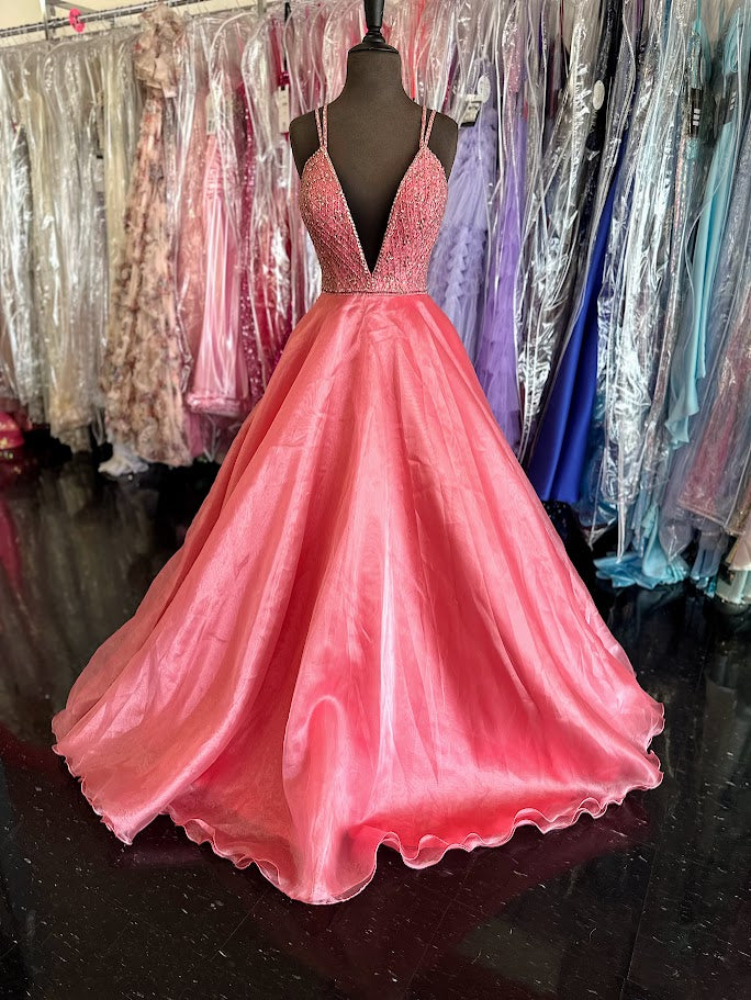 Elevate your prom night with the Johnathan Kayne 7219 long ballgown in a stunning coral hue. This size 4 dress features a graceful A-line silhouette complemented by a crystal-embellished V-neck, adding refined sparkle. Practical side pockets blend seamlessly into the design, offering convenience without sacrificing elegance. Perfect for making a memorable entrance with timeless sophistication.

Size: 4

Color: Coral