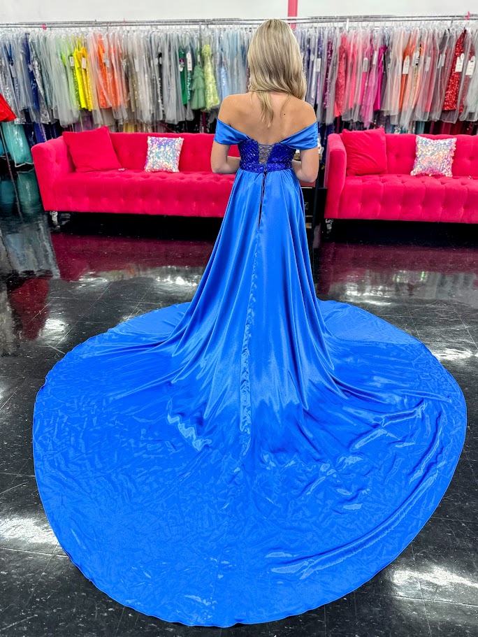 This Johnathan Kayne 2725 gown combines luxurious velvet with elegant satin details for a striking pageant look. The fitted silhouette features a straight neckline and a crystal-beaded bodice that adds refined sparkle. Detachable off-the-shoulder satin sleeves offer versatile styling, while the long satin overskirt and corset lace-up back with crystal tassels enhance both drama and fit. A tasteful slit completes this sophisticated design, perfect for making a memorable impression.

Size: 4&nbsp;

Color: Roy