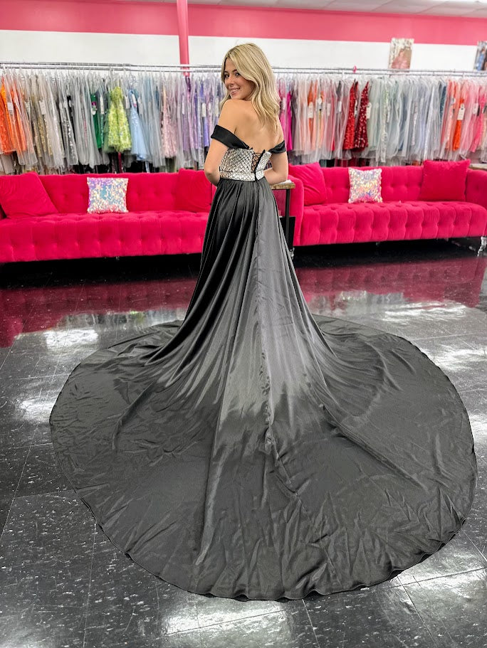 This Johnathan Kayne 2725 gown combines luxurious velvet with elegant satin details for a striking pageant look. The fitted silhouette features a straight neckline and a crystal-beaded bodice that adds refined sparkle. Detachable off-the-shoulder satin sleeves offer versatile styling, while the long satin overskirt and corset lace-up back with crystal tassels enhance both drama and fit. A tasteful slit completes this sophisticated design, perfect for making a memorable impression.

Size: 4&nbsp;

Color: Bla