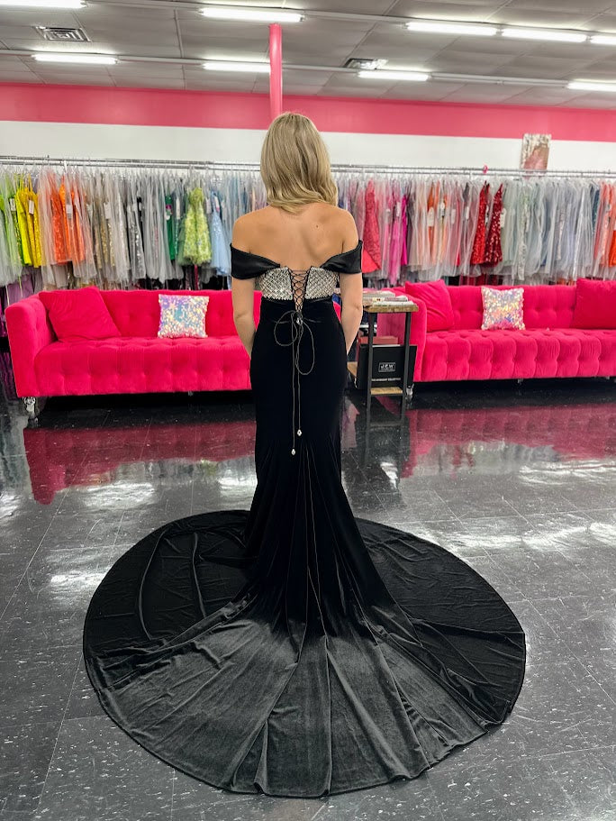 This Johnathan Kayne 2725 gown combines luxurious velvet with elegant satin details for a striking pageant look. The fitted silhouette features a straight neckline and a crystal-beaded bodice that adds refined sparkle. Detachable off-the-shoulder satin sleeves offer versatile styling, while the long satin overskirt and corset lace-up back with crystal tassels enhance both drama and fit. A tasteful slit completes this sophisticated design, perfect for making a memorable impression.

Size: 4&nbsp;

Color: Bla