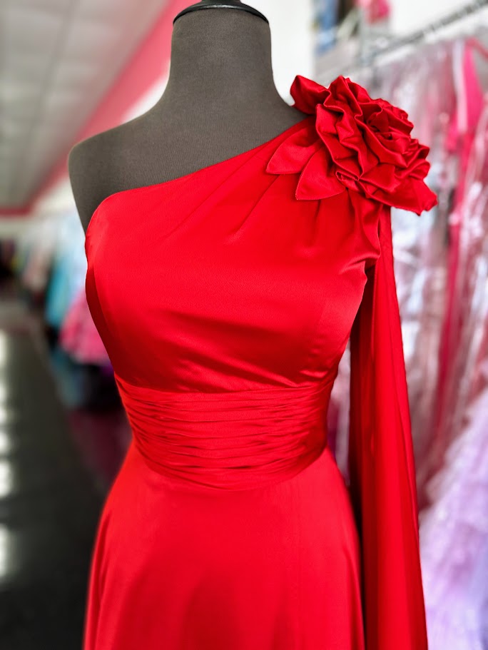 Elevate your formal occasion with this Johnathan Kayne gown, featuring a striking one-shoulder design and a flowing satin cape. The vibrant red fabric drapes elegantly, complemented by a tasteful slit and delicate floral accents. Tailored in size 4, this long dress combines classic sophistication with modern flair, perfect for pageants or special appearances.

Size: 4

Color: Red