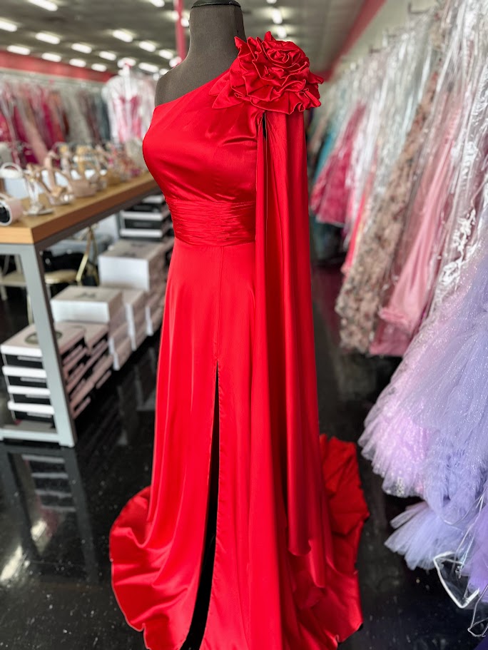 Elevate your formal occasion with this Johnathan Kayne gown, featuring a striking one-shoulder design and a flowing satin cape. The vibrant red fabric drapes elegantly, complemented by a tasteful slit and delicate floral accents. Tailored in size 4, this long dress combines classic sophistication with modern flair, perfect for pageants or special appearances.

Size: 4

Color: Red
