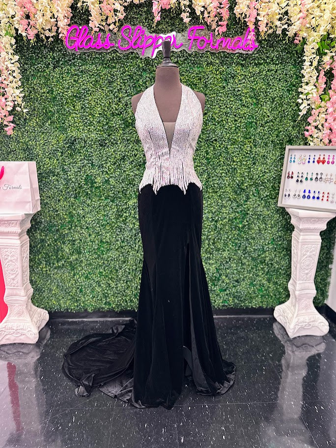 Elevate your formal wardrobe with the Johnathan Kayne 2534 gown, expertly crafted in rich black velvet. This size 4 dress features a crystal-embellished bodice that adds refined sparkle, while the halter corset design offers structured support and a flattering silhouette. The long fitted skirt includes a tasteful slit, combining elegance with a touch of allure—ideal for pageants or upscale events. This gown balances sophistication and glamour, ensuring you make a confident statement at any special occasion.