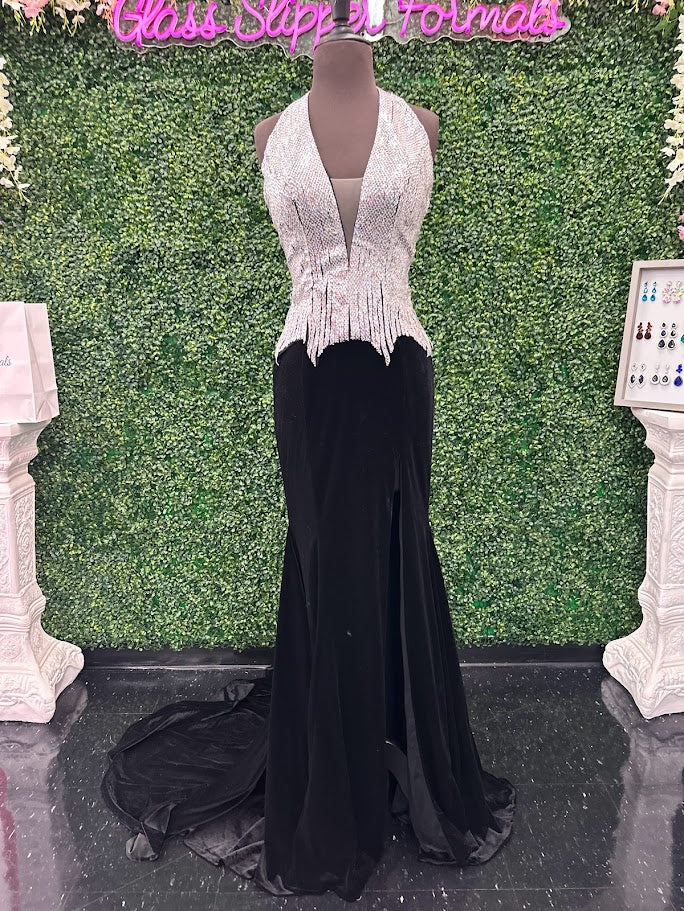 Elevate your formal wardrobe with the Johnathan Kayne 2534 gown, expertly crafted in rich black velvet. This size 4 dress features a crystal-embellished bodice that adds refined sparkle, while the halter corset design offers structured support and a flattering silhouette. The long fitted skirt includes a tasteful slit, combining elegance with a touch of allure—ideal for pageants or upscale events. This gown balances sophistication and glamour, ensuring you make a confident statement at any special occasion.