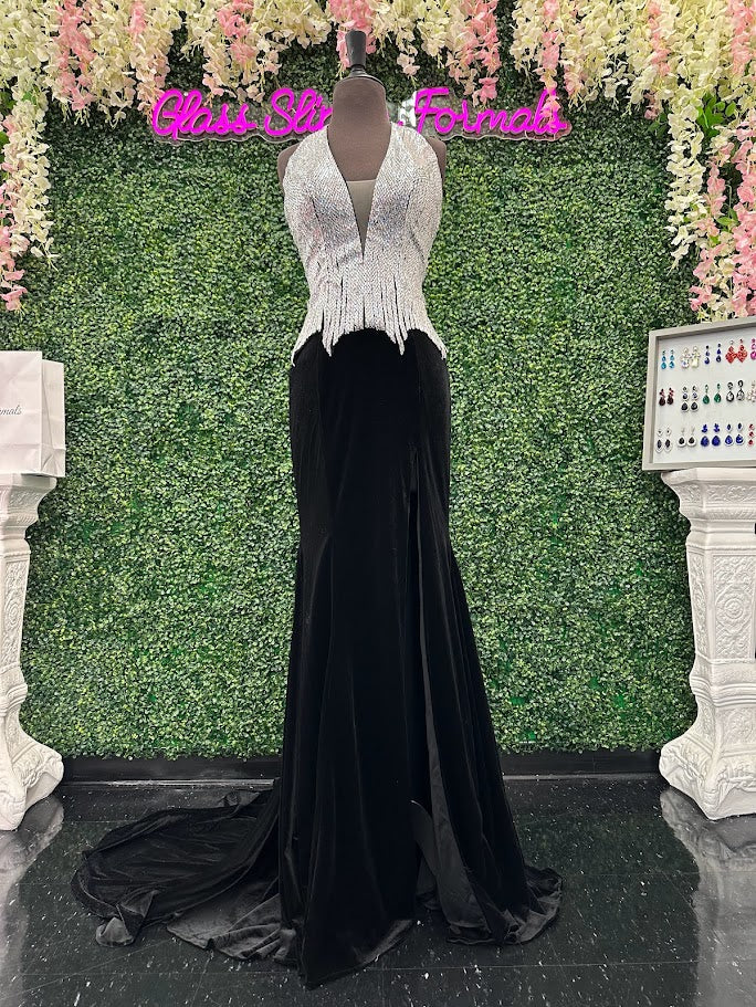 Elevate your formal wardrobe with the Johnathan Kayne 2534 gown, expertly crafted in rich black velvet. This size 4 dress features a crystal-embellished bodice that adds refined sparkle, while the halter corset design offers structured support and a flattering silhouette. The long fitted skirt includes a tasteful slit, combining elegance with a touch of allure—ideal for pageants or upscale events. This gown balances sophistication and glamour, ensuring you make a confident statement at any special occasion.