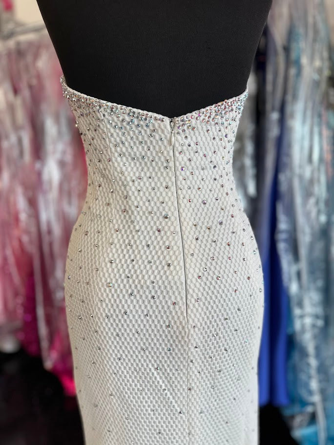 Elevate your evening with this exquisite Jovani 33132 mermaid gown in pristine white. Designed in a size 4, this long prom dress features a strapless sweetheart neckline that beautifully frames the shoulders. Adorned with delicate crystal embellishments, it offers a refined sparkle perfect for pageants or formal occasions. The fitted silhouette gracefully accentuates your figure, ensuring a stunning and sophisticated presence at any event.

Size: 4

Color: White