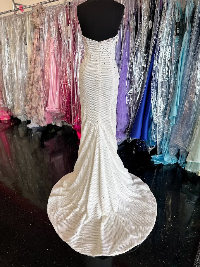 Elevate your evening with this exquisite Jovani 33132 mermaid gown in pristine white. Designed in a size 4, this long prom dress features a strapless sweetheart neckline that beautifully frames the shoulders. Adorned with delicate crystal embellishments, it offers a refined sparkle perfect for pageants or formal occasions. The fitted silhouette gracefully accentuates your figure, ensuring a stunning and sophisticated presence at any event.

Size: 4

Color: White