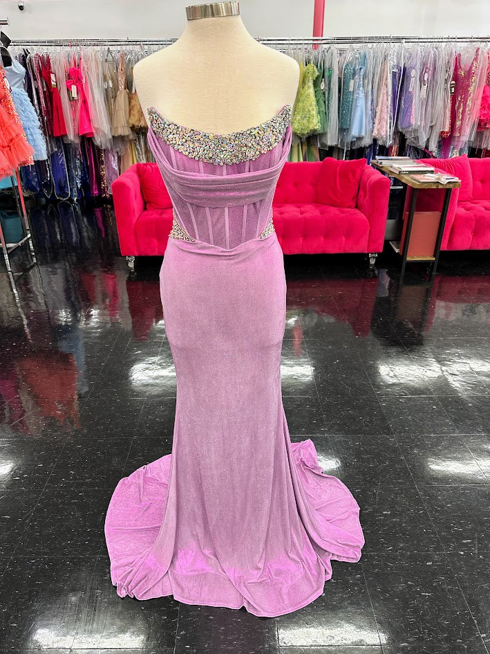 Indulge in opulence with the Jovani D5079 Long Fitted Metallic Prom Dress. Featuring a crystal corset bodice, sheer cut outs, and elegant train, this formal gown exudes luxury. With a figure-hugging fit and metallic fabric, this dress is perfect for making a statement at any special occasion.

Sizes: 10

Colors: Lilac