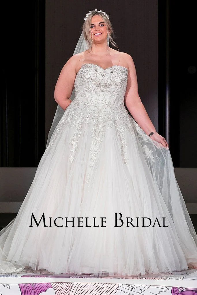 Michelle Bridal For Sydney's Closet MB1819 A-Line Sweetheart Neckline Strapless Lace Up Back Heavily Beaded Bodice Plus Size "Vanessa" Bridal Gown. Impress your guests on your special day with the luxurious Vanessa bridal gown from Michelle Bridal for Sydney's Closet. Crafted with a sweetheart neckline and a heavily beaded bodice, this strapless A-line gown also features a stylish lace-up back. Make a lasting impression in this plus size dress.