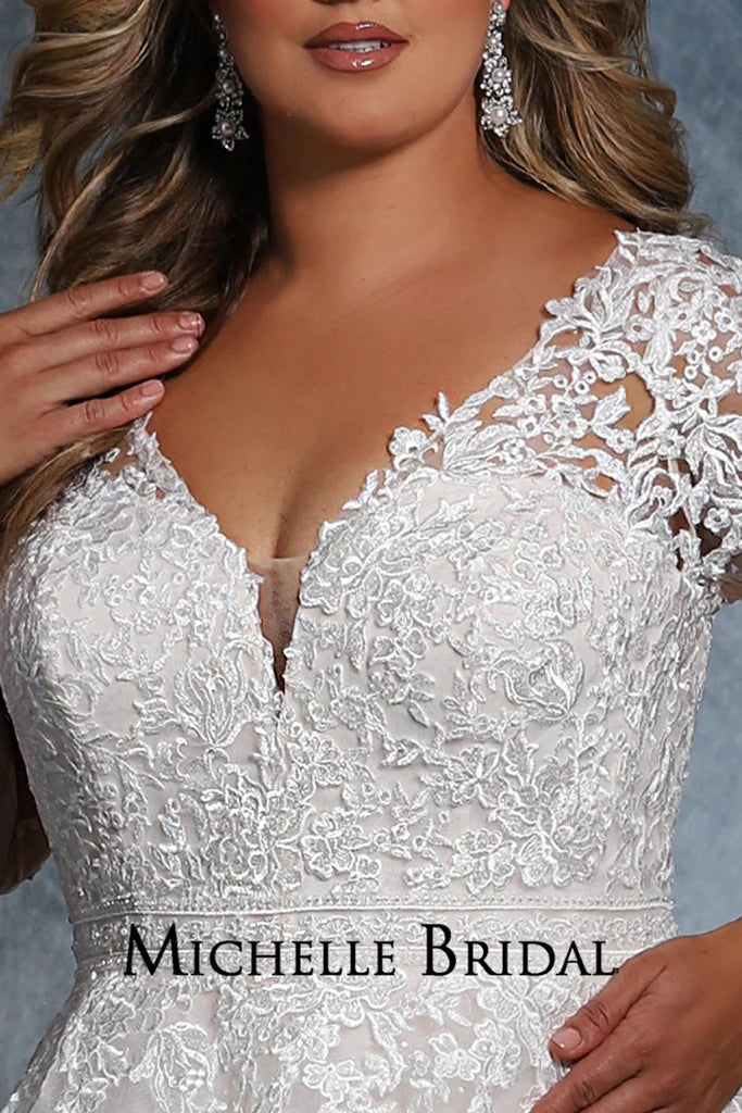 Michelle Bridal For Sydney's Closet MB2110 A-Line Long Sleeve Crystal Buttons Embroidered Floral Appliques V-Neck Plus Size "Cyndi" Bridal Gown. Look flawless in this full-length "Cyndi" bridal gown from Michelle Bridal for Sydney's Closet. This A-line dress features long sleeves, crystal buttons, embroidered floral appliques, and a V-neckline for a stunning profile. Plus size available for an impeccable fit.