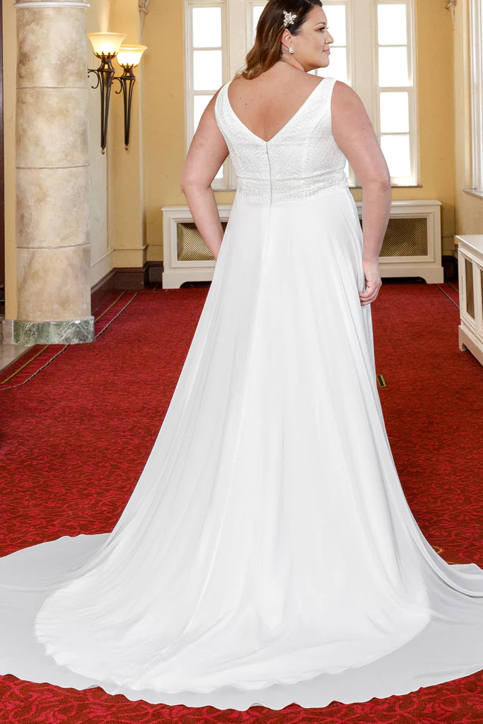 Michelle Bridal For Sydney's Closet MB2304 A-Line Bridal Chiffon Boho Lace Sleeveless V-Neck Plus Size "Taye" Bridal Dress. Look stunning on your special day in this Michelle Bridal For Sydney's Closet MB2304 A-Line dress. Features include an elegant chiffon bodice, delicate boho lace accents, sleeveless v-neck, and a beautiful A-line skirt. Perfect for the full-figured bride!