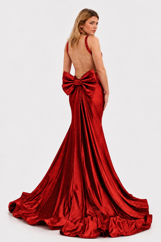 Make a stunning entrance in this Nina Canacci 9212 prom gown, expertly crafted from luxurious crystal-studded jersey. The backless silhouette showcases elegant lines while the detachable oversized bow adds dramatic flair. A removable overskirt transforms the mermaid base into a sophisticated formal statement piece. Perfect for prom, pageants, or black-tie events, this gown combines timeless elegance with contemporary design details that command attention.

Sizes: 4

Colors: Red