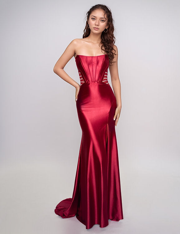Make a bold entrance with the Nina Canacci 5307 gown. This long, fitted strapless dress features a seductive corset silhouette with sheer panels that hint at allure, while the satin fabric drapes smoothly across your figure. A daring thigh-high slit adds movement and confidence, perfect for unforgettable evenings and prom night glamour.

Size: 0-12

Color: Burgundy, Navy, Emerald