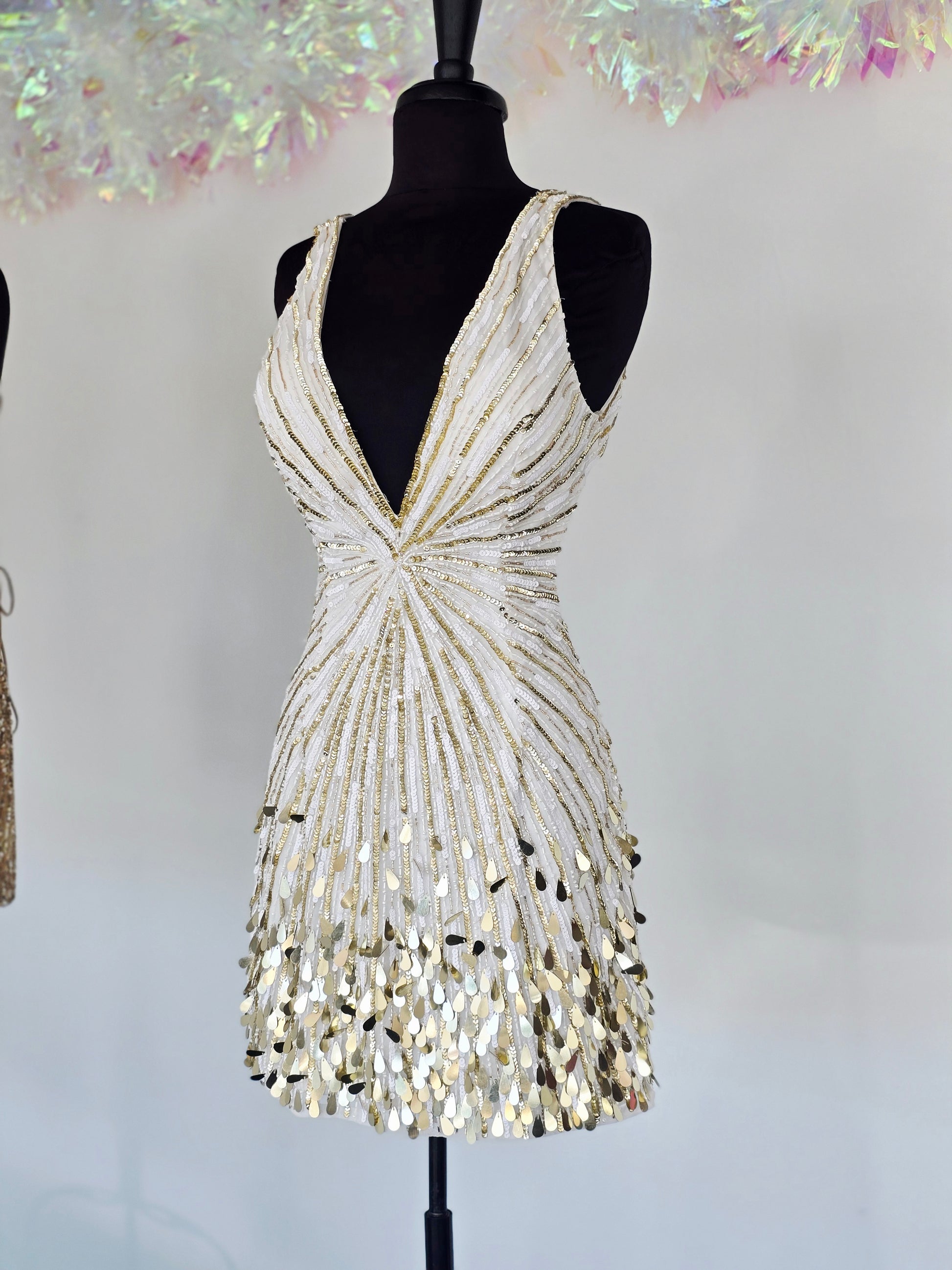 Step into the spotlight with the Primavera Couture 4417, a short backless cocktail gown designed to dazzle. Featuring a flattering V-neck and shimmering sequins, this homecoming dress combines elegance with a playful edge. Its backless design adds a touch of allure, perfect for making unforgettable memories at your special event. Comfortable and stylish, it’s crafted to help you feel confident and radiant all night long.

Sizes: 6

Colors: Ivory/Gold