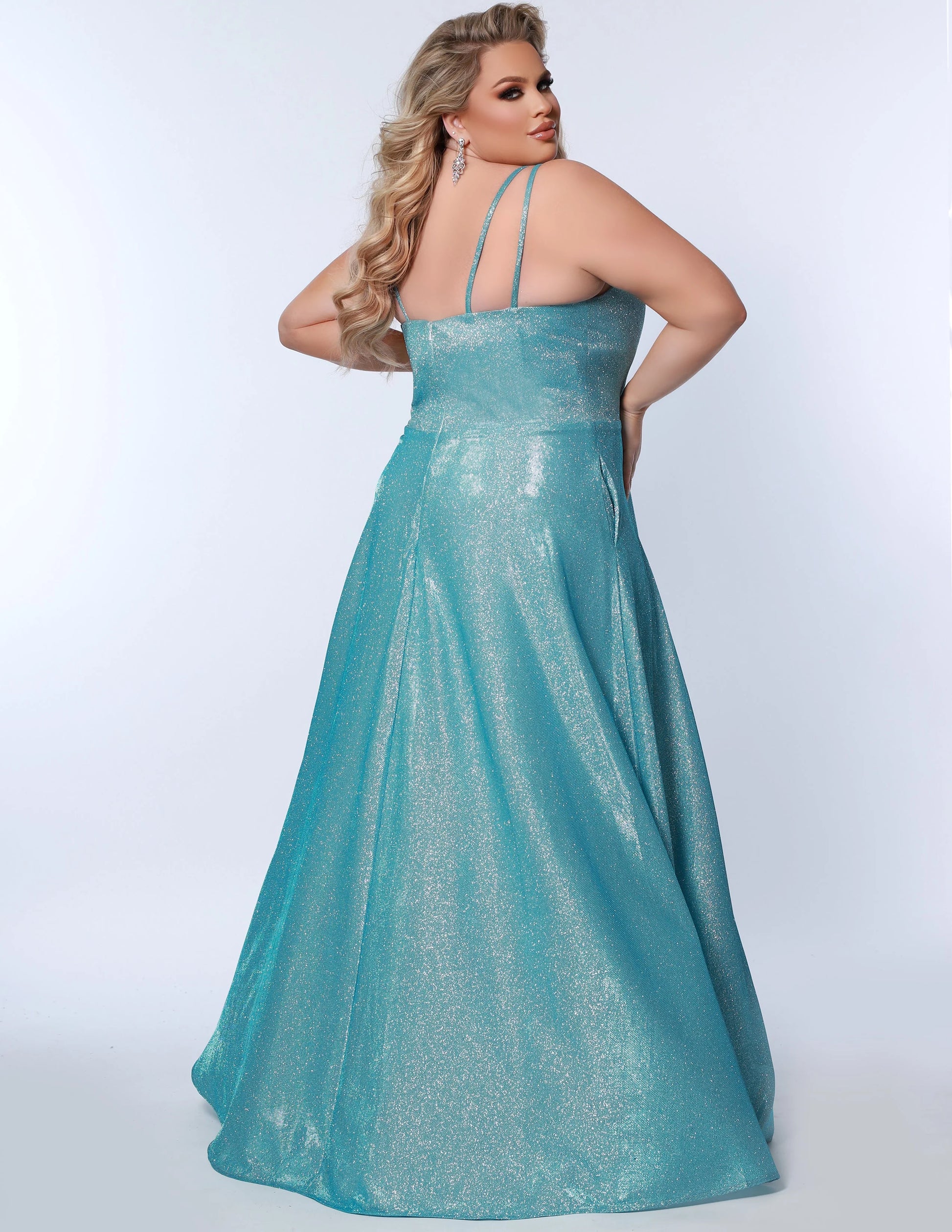 This plus-sized prom dress from Sydney's Closet SC7349 is made of shimmering knit and features an A-line silhouette, scoop neckline, double straps, zip-up back, natural waist, A-line skirt with slit, and hidden pockets. Fully lined for a comfortable and flattering fit. Perfect for special occasions. Keep it sweet and sparkly when you wear our classic A-line plus size prom dress! 