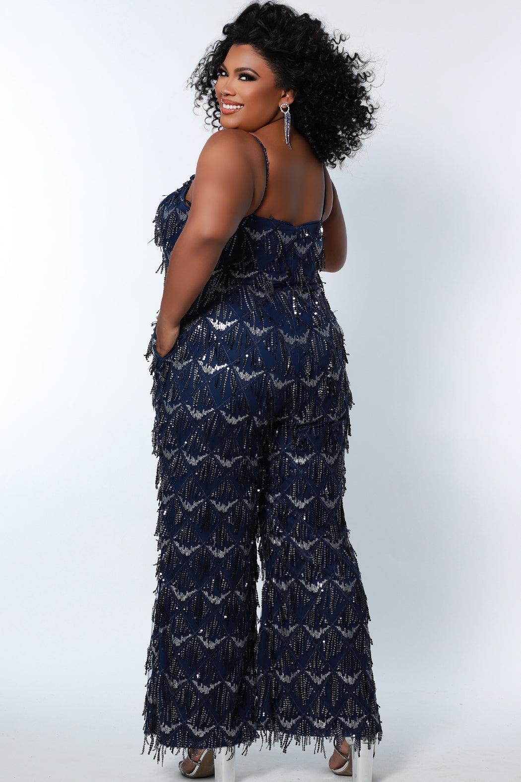 Sydney's Closet SC9108 Long Plus Size Sequin Fringe Jumpsuit Formal Pockets V Neck  Color: Diamond White, Navy, Sangria Size: 14-28 Sequin fringe Jumpsuit Spaghetti straps covered in sequins V-neckline Pockets Natural waistline Wide leg pant